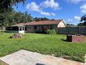 Spacious backyard featuring a brick fire pit, ample greenery and concrete slab at 2105 E Cherokee St, Bartow, FL 33830