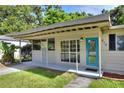 The front of the home has a covered porch area and a bright blue front door at 215 W Valencia St, Lakeland, FL 33805