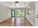 Bright living room featuring hardwood floors, a large window, and a decorative front door at 215 W Valencia St, Lakeland, FL 33805