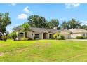 Inviting single-story home with green lawn and mature landscaping, showcasing its charming curb appeal on a sunny day at 2208 Deerbrook Dr, Lakeland, FL 33811