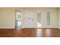 Bright entryway featuring hardwood floors, white trim, and a contemporary white front door with sidelights at 2219 Starboard Rd, Winter Haven, FL 33881
