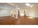 Expansive living room with wood floors, recessed lights, ceiling fans, and natural light from several skylights at 2219 Starboard Rd, Winter Haven, FL 33881