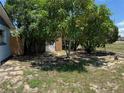 Backyard featuring mature trees, partial fencing, and partially grassed ground at 225 W Orange St, Lake Alfred, FL 33850