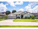 Beautiful single-Gathering home featuring a well-maintained lawn, a two-car garage and mature landscaping at 4222 Juliana Lake Dr, Auburndale, FL 33823