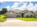 Beautiful single-Gathering home featuring a two-car garage, mature landscaping and well-manicured lawn at 4222 Juliana Lake Dr, Auburndale, FL 33823