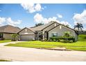 Beautiful one-story home featuring lovely landscaping, a gray stucco exterior, and a two-car garage at 4222 Juliana Lake Dr, Auburndale, FL 33823
