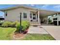 Inviting home entrance featuring a manicured garden and covered parking at 451 Village Sw Cir, Winter Haven, FL 33880