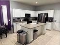 Bright kitchen featuring white cabinets, stainless steel appliances, a kitchen island, and neutral countertops at 4665 Sw 40Th Pl, Ocala, FL 34474