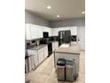 Bright kitchen featuring white cabinets, stainless steel appliances, a kitchen island, and neutral countertops at 4665 Sw 40Th Pl, Ocala, FL 34474