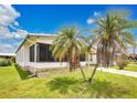 View of the side of a single Gathering home with well maintained lawn and palm trees at 6443 Hollyberry Ne Ln, Winter Haven, FL 33881