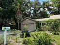 Attached garage with a neutral door, set amongst mature greenery and a colorful mailbox at 645 Avenue A Ne, Winter Haven, FL 33881