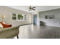 Bright living room with an accent brick wall, stylish wood floors, and natural light at 686 22Nd Nw St, Winter Haven, FL 33880