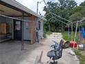 Carport area showing open-air shelter and overgrown yard at 745 Drawdy Rd, Babson Park, FL 33827