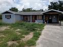 Exterior shot of property showing the house, overgrown yard, and driveway at 745 Drawdy Rd, Babson Park, FL 33827