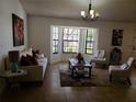 Cozy living room with bay window, neutral furniture, stylish decor, and ample natural light at 1470 Ne Old Mill Dr, Deltona, FL 32725
