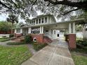 Brick house with a large front porch and a spacious lawn at 214 S Riverside Dr, New Smyrna Beach, FL 32168