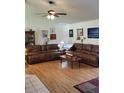 Spacious living room with hardwood floors, ceiling fan, and comfortable brown leather couches at 806 South St, New Smyrna Beach, Fl 32168, FL 32168