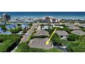 An aerial view shows the property nestled amongst mature trees, a neighborhood street, and the ocean in the distance at 4303 Sea Mist Dr # 225, New Smyrna Beach, FL 32169