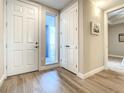 Bright hallway with wood-look tile floors, closet, and access to balcony at 1 Riverwalk Dr # 202, New Smyrna Beach, FL 32169
