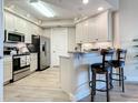 Modern kitchen with stainless steel appliances and breakfast bar seating at 1 Riverwalk Dr # 202, New Smyrna Beach, FL 32169