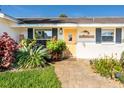 Inviting front entrance with a decorative 'ALOHA' sign, a yellow door and lush tropical plants at 4606 Doris Dr, New Smyrna Beach, FL 32169