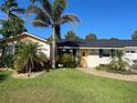 Inviting single-story home showcases well-maintained landscaping, a brick pathway, and a lovely, bright entrance at 4606 Doris Dr, New Smyrna Beach, FL 32169