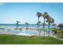 Relaxing pool area with ocean views, palm trees, lounge chairs and beach access at 3663 S Atlantic Ave # 21C, New Smyrna Beach, FL 32169