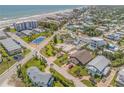 Aerial view of a coastal community with beach access and a tennis court. Several homes have private pools at 327 Due East St, New Smyrna Beach, FL 32169