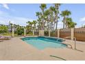 Backyard pool with privacy fence and mature palm trees; features clear blue water and a waterfall feature at 327 Due East St, New Smyrna Beach, FL 32169