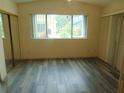 Bright bedroom with a large window, closet, and modern wood flooring at 714 Fox Tail Ct, New Smyrna Beach, FL 32168
