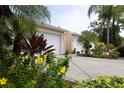 Two-car garage and landscaped entry with flowering plants at 2290 Hawks Cove Cir, New Smyrna Beach, FL 32168