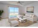 Bright living room featuring a white sectional sofa and a sliding glass door with ocean views at 3180 Ocean Shore Blvd # 208, Ormond Beach, FL 32176