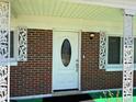 Close-up of the home's front door with decorative metalwork and brick surround at 1119 Edith Dr, Daytona Beach, FL 32117