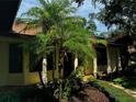 A home exterior features manicured landscaping with palm trees that frame the house creating a tropical ambiance at 1780 Otisco Way, Winter Springs, FL 32708