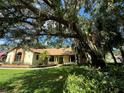 A beautifully landscaped front yard and charming home with a brick facade and mature oak trees create inviting curb appeal at 1780 Otisco Way, Winter Springs, FL 32708