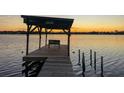 Picturesque sunset view from a wooden pier with a bench overlooking the tranquil water at 1949 Bayview Dr, New Smyrna Beach, FL 32168