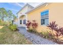 Welcoming walkway leads to a charming home exterior with beautiful landscaping and natural light at 306 Coral Reef Way, Daytona Beach, FL 32124