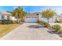 Charming home featuring a paver driveway, two-car garage, and well-maintained landscaping at 306 Coral Reef Way, Daytona Beach, FL 32124