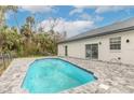 Relaxing kidney-shaped pool with gray pavers and fenced backyard at 1371 Melonie Trl, New Smyrna Beach, FL 32168