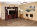 Open living room featuring wood-look floors, a ceiling fan, and a media center for cozy living at 400 Oakridge Blvd # 6, Daytona Beach, FL 32118