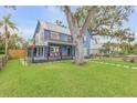Beautiful two-story blue home with a welcoming porch, set on a lush green lawn, showcasing curb appeal at 532 Faulkner St, New Smyrna Beach, FL 32168