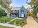 Charming two-story blue home with inviting front porch and balcony, surrounded by a well-manicured lawn at 532 Faulkner St, New Smyrna Beach, FL 32168