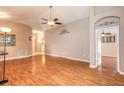 Open-concept living room with wood floors, neutral walls, and arched doorway at 6793 Calistoga Cir, Port Orange, FL 32128