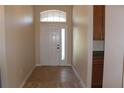 Bright entryway showcasing tile floors and a door with an arched window above at 537 Coral Trace Blvd, Edgewater, FL 32132