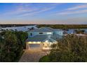 Beautiful waterfront home with a lush landscaped yard, brick driveway, and attached garage at 73 Cunningham Dr, New Smyrna Beach, FL 32168