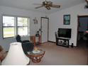 Bright living room featuring a ceiling fan, large TV, and comfy seating at 2325 Date Palm Dr, Edgewater, FL 32141