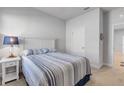Cozy bedroom featuring a comfortable bed with striped bedding, a nightstand with a lamp, and neutral walls at 270 Eagle Harbor Way, Daytona Beach, FL 32124