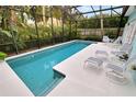 Inviting screened-in pool with lounge chairs and patio furniture at 915 Maple St, New Smyrna Beach, FL 32169