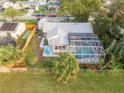 Aerial view of fenced backyard with pool, patio, and putting green, surrounded by neighborhood at 1052 Tompkins Dr, Port Orange, FL 32129
