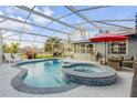 Screened-in pool and spa area perfect for relaxation and outdoor entertaining with a patio set at 1052 Tompkins Dr, Port Orange, FL 32129